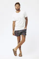 Short de baño con estampado de hojas de palmera en tonos beige, verde y naranja.