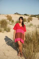 Vestido tejido con escote en V, corte a la rodilla y tajos laterales. Diseño a rayas horizontales en tonos rojo, rosa y marrón.