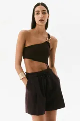 Short marrón de lino con cintura elastizada y cordón ajustable. Presenta pliegues frontales, bolsillos laterales y corte holgado.