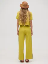 Pantalón negro de algodón, corte holgado y pierna ancha con pretina elástica. Presenta rayas blancas y celestes a los costados.