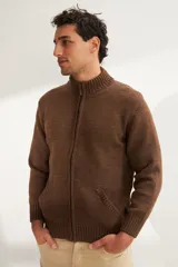 Campera de lana color crema, tejida con cierre delantero, cuello alto y bolsillos delanteros.