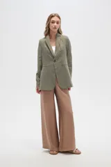 Blazer blanco de lino con hombreras, corte entallado, cuello solapa y cierre con botón.