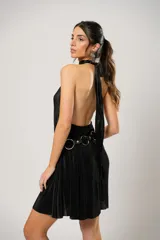Vestido corto negro plisado con cuello halter y espalda baja. Incluye cinturón de cuero con aros metálicos.