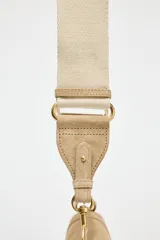 Bandolera de gamuza color beige, con asa corta y cierre imantado.