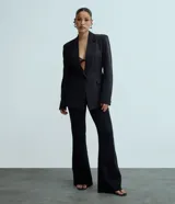 Pantalón flare negro de punto roma con viscosa certificada, cintura incorporada y sin estampado.