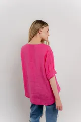 Blusa verde salvia de lino, con escote en V, manga corta y un botón de madera al frente.