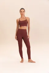 Calza larga color ladrillo, de compresión media y textura acanalada. Presenta un detalle de macramé hecho a mano en los laterales.
