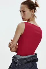 Camiseta sin mangas color fucsia, de corte ajustado y cuello barco.