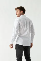 Camisa blanca de manga larga, corte slim fit, con logo bordado y cartera con botones.