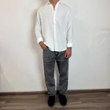 Camisa de lino color verde militar, de manga larga con puños abotonados y cuello clásico. Cierre frontal con botones.