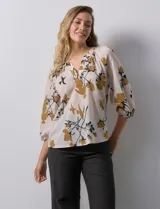 Blusa de gasa verde con estampado floral blanco y celeste, cuello a la base con escote en V y mangas 3/4 fruncidas.