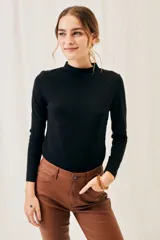 Polera negra de algodón y elastano, con cuello alto y mangas largas, corte ajustado al cuerpo.