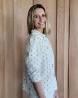 Camisa color beige claro con cuello con volados y mangas 3/4 abullonadas.