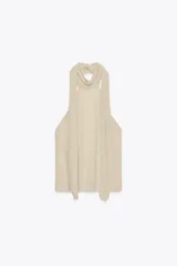Top de cuello halter color beige, con lazada tipo foulard, forro interior y cierre lateral con cremallera oculta.