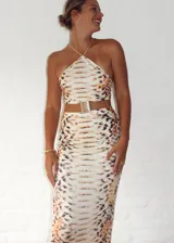 Vestido midi con estampado de piel de serpiente en tonos beige y marrón. Diseño con top halter y falda tubo con abertura lateral.