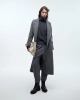 Pantalón pinzado sastrero color marrón claro, confeccionado en tela italiana de lana y elastano, de tiro medio/alto y largo hasta los tobillos. Presenta una silueta baggy, cintura prearmada, cartera con cierre y botón, bolsillos laterales funcionales y doble pinza en cada pierna. En la espalda, pinzas y un bolsillo ojal con presilla y botón.