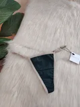 Microtanga verde con terminaciones en color beige y tiras finas regulables.