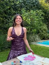 Vestido corto de lentejuelas color verde oliva, con escote en V, breteles finos cruzados en la espalda, cut-outs laterales y volado en el ruedo.