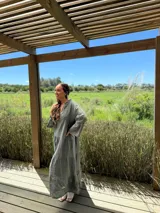 Vestido largo azul marino de lino con cuello mao, escote en V, mangas 3/4 con volados y corte escalonado. Diseño amplio y cómodo.