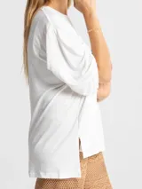 Remerón blanco de algodón, con mangas 3/4 con pliegues y elástico en el puño, y aberturas laterales en el ruedo.