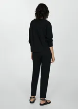 Pantalón negro de piqué con cintura elástica, tiro alto, diseño jogger, bolsillos laterales y costuras decorativas.