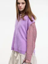 Chaleco sin mangas de cashmere color blanco, con escote en V y tajos laterales.
