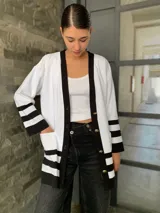 Saco blanco con ribetes negros, de tejido de punto y corte oversize.