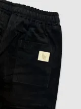 Pantalón de pana verde militar con cintura elastizada, cordón de algodón, bolsillos laterales y un bolsillo trasero.