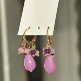 Aros colgantes dorados con cierre de gancho, adornados con piedras de colores y perlas de río.