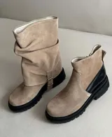 Bota de cuero color marrón oscuro, con caña media arrugada y hebilla lateral.