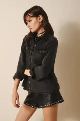 Camisa de manga larga confeccionada en tencel azul denim, de corte clásico, con cuello camisero, bolsillos en el frente y botones metálicos.