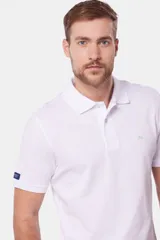 Remera polo de piqué blanca, lisa, con cuello en rib y botones personalizados.