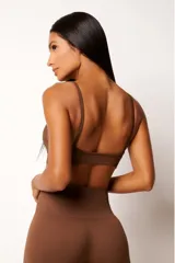 Top deportivo marrón con tecnología seamless, calce slim, breteles finos y textura con microtramas respirables. Cuenta con forro interno.