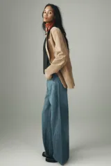 Jeans de tiro alto con pierna ancha y largo completo. Confeccionados en tejido rígido con cinco bolsillos, cintura con trabillas, detalle de costuras torcidas y cierre con cremallera y botón metálico.