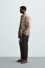Pantalón negro de lino, corte recto y relaxed fit, con cintura elástica ajustable con cordón, bolsillos laterales y traseros.
