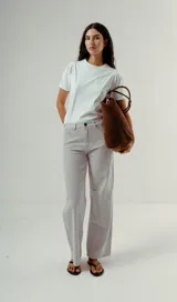 Pantalón wide leg de denim, tiro alto, color gris claro con finas rayas verticales blancas.