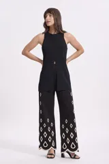 Musculosa negra de tejido texturizado con cuello redondo y tajo central.
