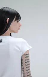 Remera blanca de manga corta, corte ajustado y largo a la cadera.