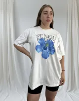 Remerón blanco de corte holgado con estampa de hibisco azul y texto en negro.