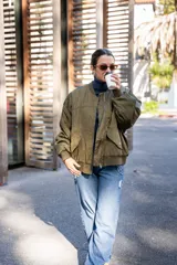 Campera estilo aviadora color verde militar, con bolsillos con cierre metalizado y forro naranja.