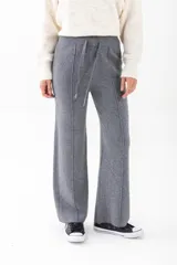 Pantalón de punto color beige, de corte palazzo y cintura con cordón ajustable.
