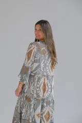 Vestido largo de corte amplio con estampado geométrico en tonos grises, marrones y blancos. Tiene cuello en V y mangas 3/4.