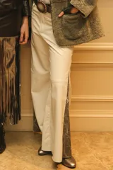 Pantalón de cuero ovino italiano color crema, corte jean con piernas anchas y aberturas laterales con tela estampada. Hecho a mano en Uruguay.
