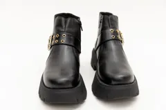 Borcego de cuero negro con plataforma y hebilla dorada decorativa.