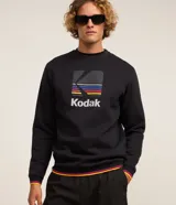 Buzo negro de algodón y poliéster con cuello redondo y mangas largas. Estampado frontal con el logo de Kodak a rayas de colores.