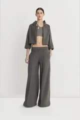 Pantalón gris de corte amplio con detalle de alforza central, recortes laterales y cintura elastizada en la espalda.