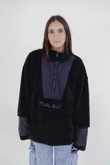 Canguro negro de polar con cierre de cremallera parcial, cuello alto y mangas largas con puños de tela lisa. Tiene un bolsillo tipo canguro con el logo de la marca bordado en el frente.