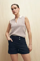 Short de jean color azul oscuro, de tiro alto con detalle de doble botón metálico en la cintura, bolsillos frontales y ruedo recto.