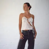 Top color champagne de seda con breteles finos, escote con frunce y lazos decorativos.