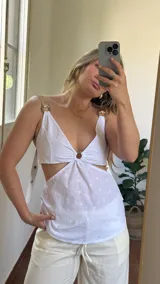 Top blanco de broderie con copas ajustables en la espalda y elástico en la cintura trasera. Breteles ajustables con detalle de ecocuero.